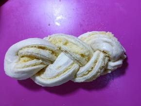 两头往底部收，将麻花面朝上，放入模具中，放入烤箱二次发酵。