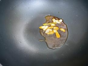 锅里加入适量植物油，放入蒜片爆香