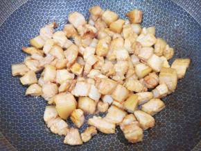 炒锅内加入花生油，放糖炒出糖色，下入五花肉煸炒出油脂。 