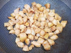 炒锅内加入花生油，放糖炒出糖色，下入五花肉煸炒出油脂。 