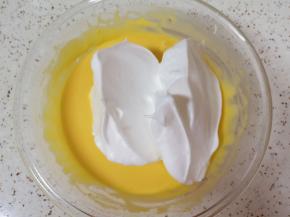 打发好的蛋白分成三份，取中间的三分之一加入到蛋黄糊里面，用硅胶刮刀采用切拌和翻拌的方法混合均匀。 烤箱上下管150度预热。 