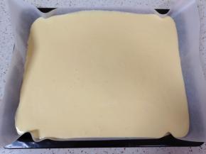 烤盘里铺上油纸，倒入蛋糕糊，轻震几下震出大气泡。 