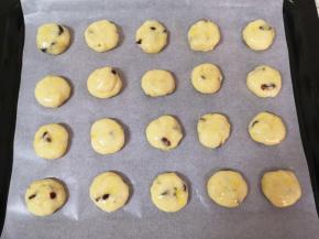烤盘里铺上油纸，将面团分成20份，搓圆按扁成小饼状放在烤盘里，刷上一层蛋液。 