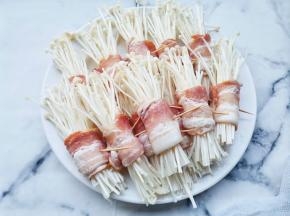将培根把金针菇卷起来用牙签固定。