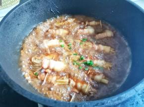 加入金针菇培根卷煮至收汁，起锅撒上葱花即可~