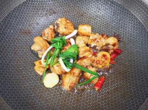 下入小葱、生姜片、干红辣椒和八角炒出香味。 