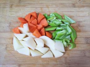 准备一下配菜:青椒、土豆和胡萝卜分别切成滚刀块备用。 