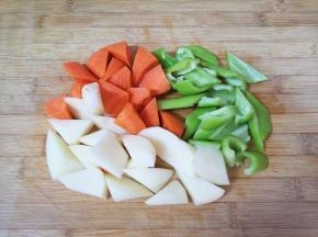 准备一下配菜:青椒、土豆和胡萝卜分别切成滚刀块备用。 