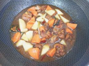 20分钟以后下入土豆和胡萝卜翻炒均匀，中火煮6分钟。 