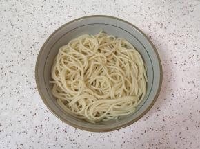 将意面捞入碗里。 