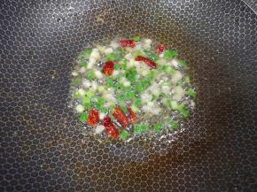 锅里继续倒油烧热，下入葱姜蒜和干红辣椒炒香。 