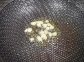 锅里继续倒油烧热，下入大蒜炒香。 