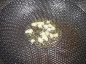 锅里继续倒油烧热，下入大蒜炒香。 