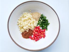 碗中放入小米椒+蒜末+葱花+白芝麻+辣椒粉，