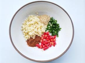 碗中放入小米椒+蒜末+葱花+白芝麻+辣椒粉，