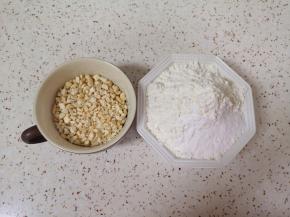 腰果仁装入保鲜袋用擀面杖擀碎，低筋面粉、小苏打和泡打粉混合均匀。