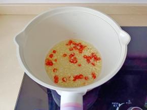 锅里放油，下蒜泥、小米椒粒爆香。