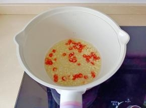 锅里放油，下蒜泥、小米椒粒爆香。