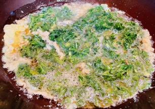 锅中倒入底油加热再倒入搅拌好的蛋液白蒿大火炒至微微定型即可轻轻翻动