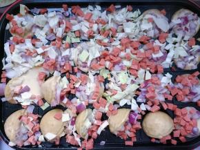 先倒面糊，齐平模具即可，依次加入虾仁、包菜、洋葱和火腿粒。慢慢将蔬菜整理到小丸子里。待面糊慢慢凝固后，将小丸子立起，空出的部分倒入少许面糊。