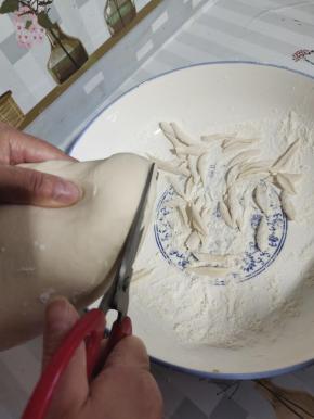 醒好的面团，用清洗干净的剪刀，剪成细条，呈柳叶状才好看，好熟！