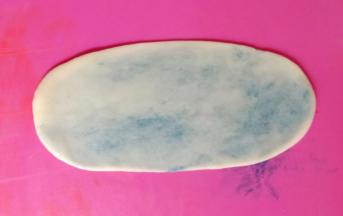 将面团收口朝上，按扁，擀成舌状。