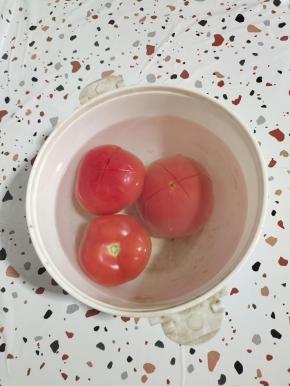 西红柿顶部打十字花刀，倒入适量的开水烫一分钟左右，这样就可以轻松的把西红柿的皮，扒掉了！