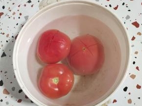 西红柿顶部打十字花刀，倒入适量的开水烫一分钟左右，这样就可以轻松的把西红柿的皮，扒掉了！