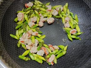 锅内放少许盐和油，加入芦笋和虾仁翻炒。
