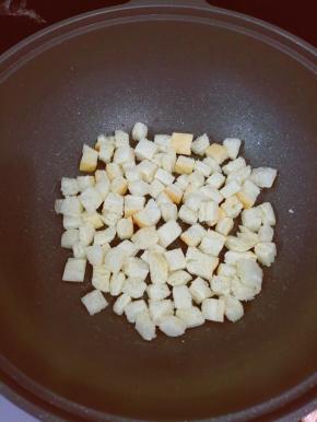 然后把面包块放入锅中，煎到面包块微黄