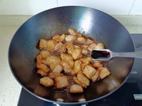 翻炒到五花肉两面微黄，加生抽两勺。