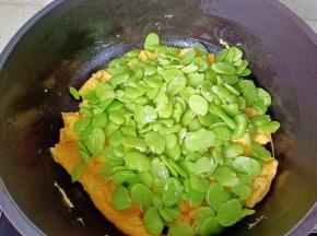 放入蚕豆快速翻炒均匀。