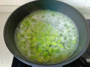 水开后蚕豆浮起捞出过一遍凉水，控干水分。