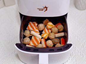 速冻丸子倒入空气炸锅炸篮中，启动解冻功能。