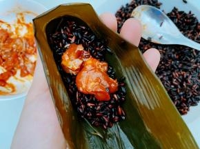 取两张粽叶折成漏斗状，装入黑米和鸡肉