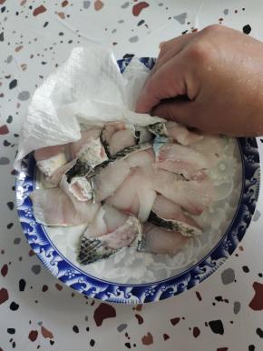 洗好的鱼片，用手按压出水分，再用厨房纸巾擦干水分！这样鱼片更容易吸收味道，更容易上浆！