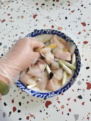 擦干水分的鱼片放入碗中，加入一小勺盐，少许胡椒粉，少许料酒或者黄酒，葱段，姜片，再放入一个蛋清抓拌均匀！抓至鱼片发粘！（放蛋清可以使鱼片更加滑嫩！）