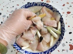 擦干水分的鱼片放入碗中，加入一小勺盐，少许胡椒粉，少许料酒或者黄酒，葱段，姜片，再放入一个蛋清抓拌均匀！抓至鱼片发粘！（放蛋清可以使鱼片更加滑嫩！）