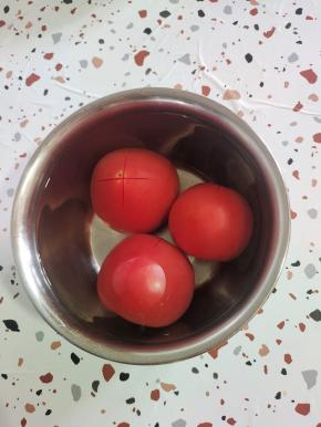 番茄在顶部切一个十字花刀，放在开水里烫一分钟左右，这样就可以很轻松的剥皮了！