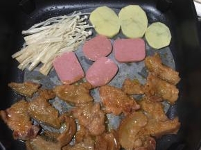 电热锅插上电源，放入一张烤肉纸，刷一层油！把腌制好的五花肉片放进去烤！把喜欢吃的配菜一起放在一边烤！