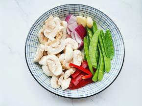 口蘑洗净切厚片，荷兰豆去茎，洋葱切块，辣椒切条，大蒜拍扁。