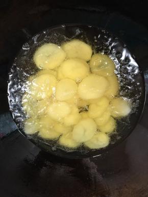 锅烧热倒入适量的油烧至七成热，放入土豆片炸至表面金黄色捞出控油备用！