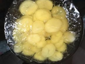 锅烧热倒入适量的油烧至七成热，放入土豆片炸至表面金黄色捞出控油备用！