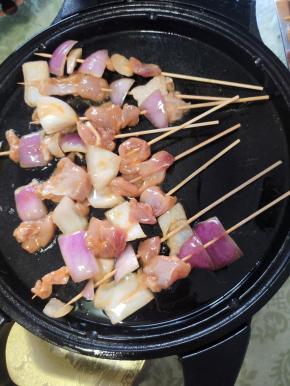 电饼铛预热，刷一层油，把串好的鸡肉串放进去烤！再在鸡肉表面也刷一层油！