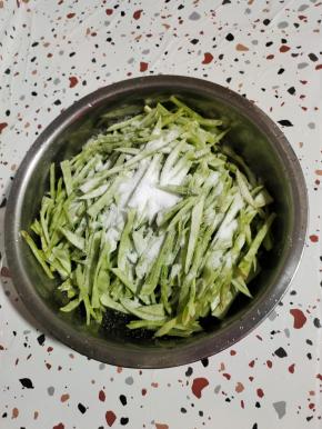 切好的梅豆丝装入盆中，放入一大把盐！（盐要比平时炒菜稍微多一点儿！）