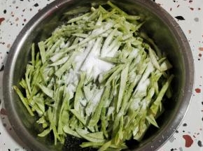 切好的梅豆丝装入盆中，放入一大把盐！（盐要比平时炒菜稍微多一点儿！）