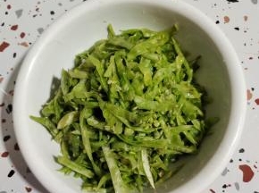 腌制好的梅豆丝挤干水分放入碗中！