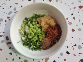 碗中放入葱末，蒜泥，花椒面，辣椒面！