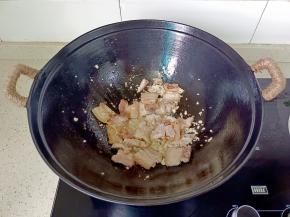 爆炒到五花肉两面金黄，油脂渗出，加蒜泥炒香。