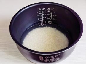 大米淘洗好后倒入电饭煲内胆中，加入生抽清水，水量比平时少一点点。